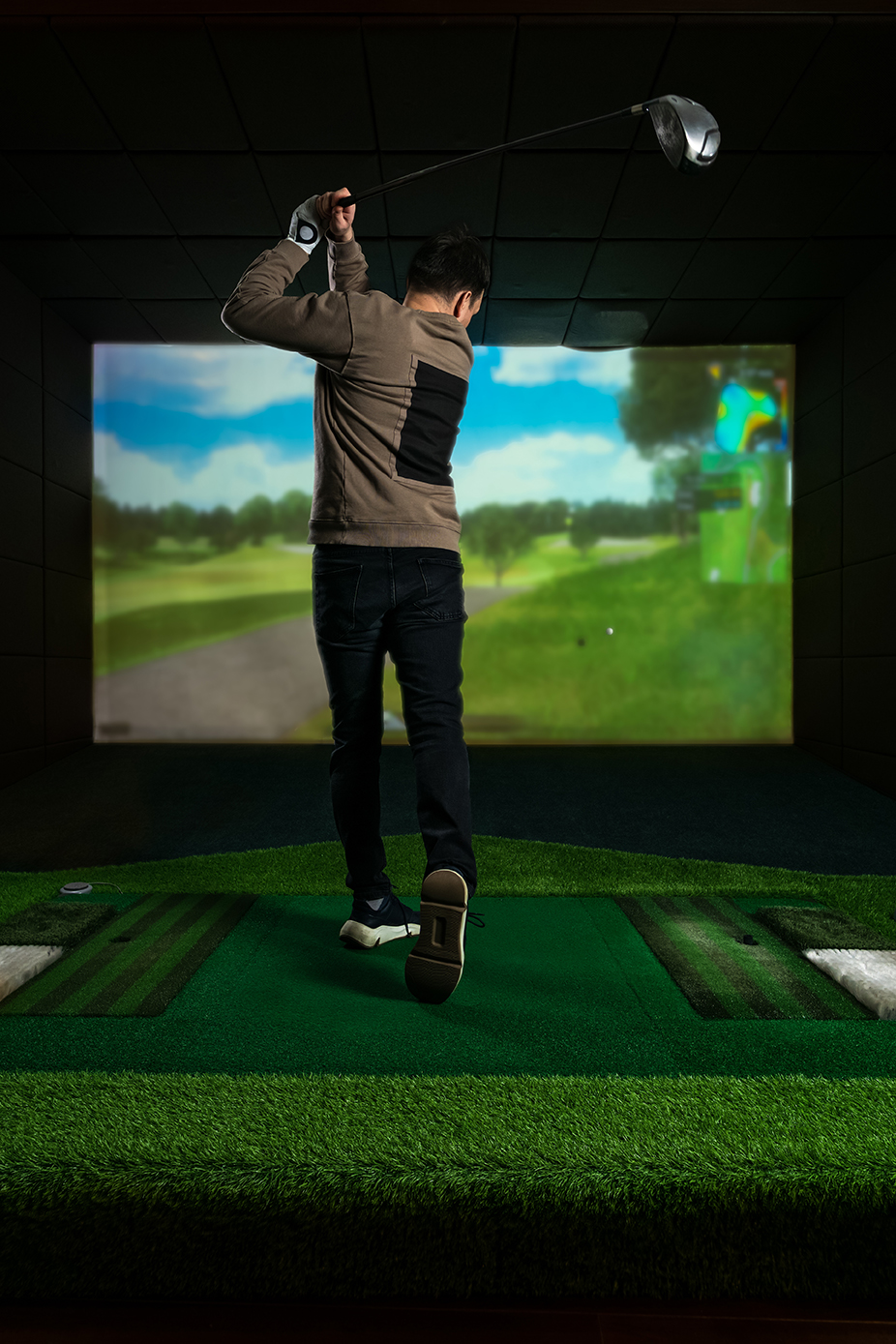 A man playing screen golf. Golf Simulator. Young golf player having playing video-game golf indoors